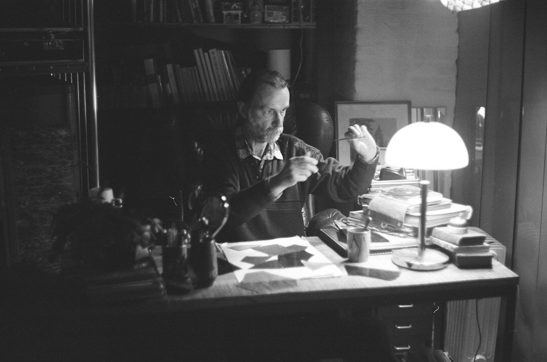 Portrait of a Croatian mystery novelist sitting at a wooden desk with an old typewriter under lamp light