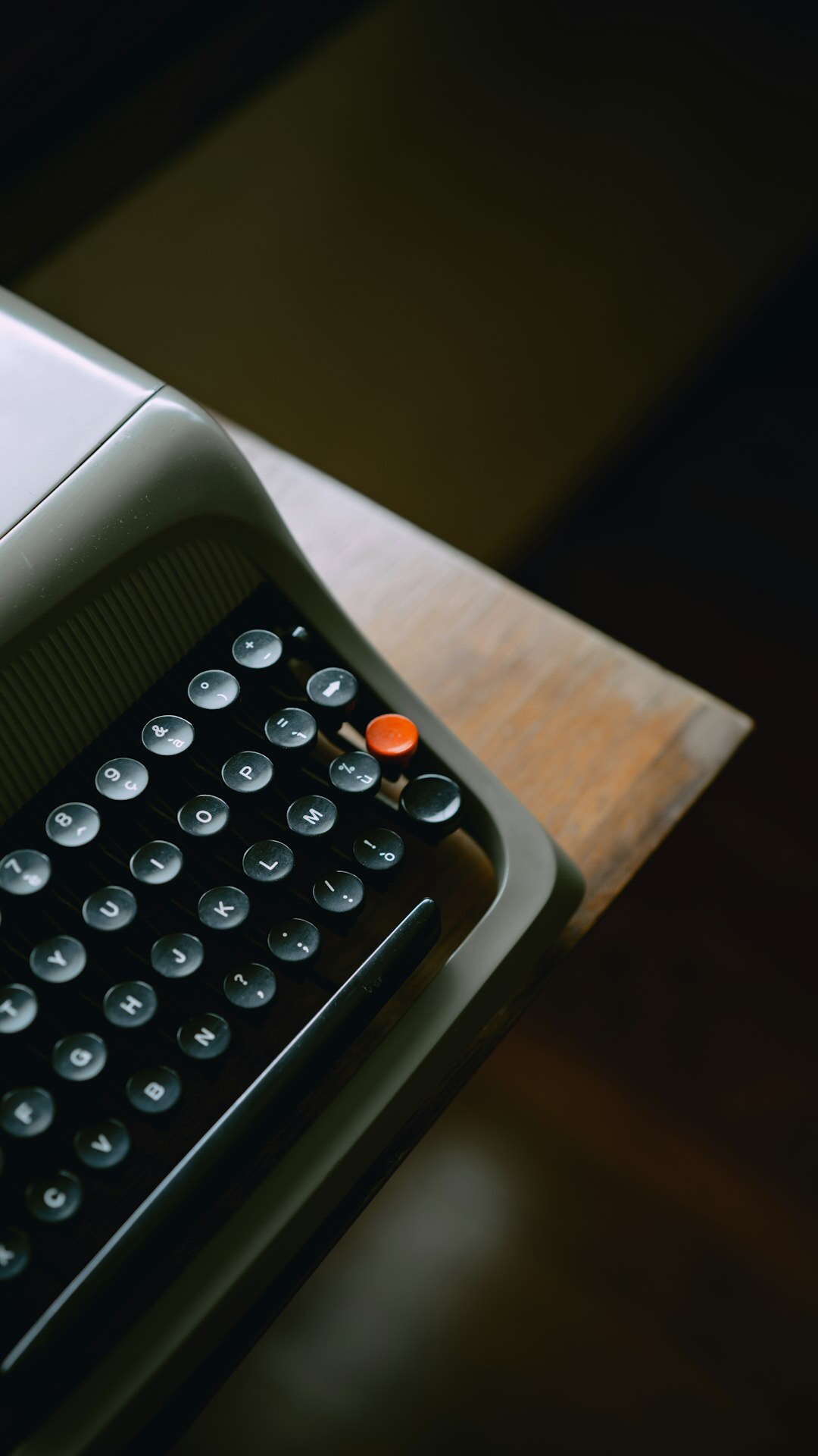 Close-up of a vintage typewriter with a sheet of paper on a wooden writing desk